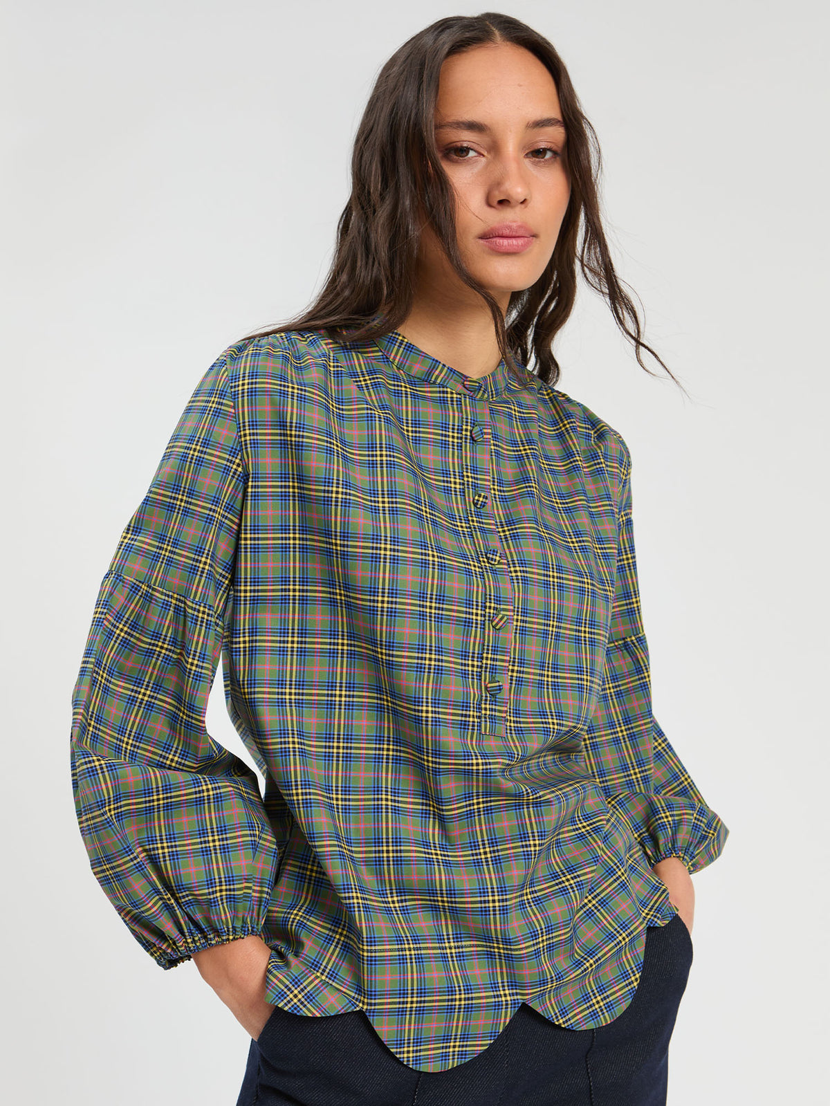 Camisa de cuadros con bajo ondulado y cuello mao.
